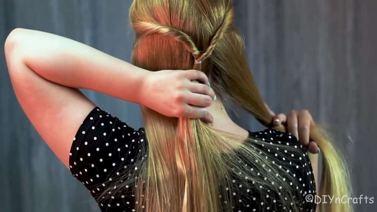 sides of hair being sectioned to braid