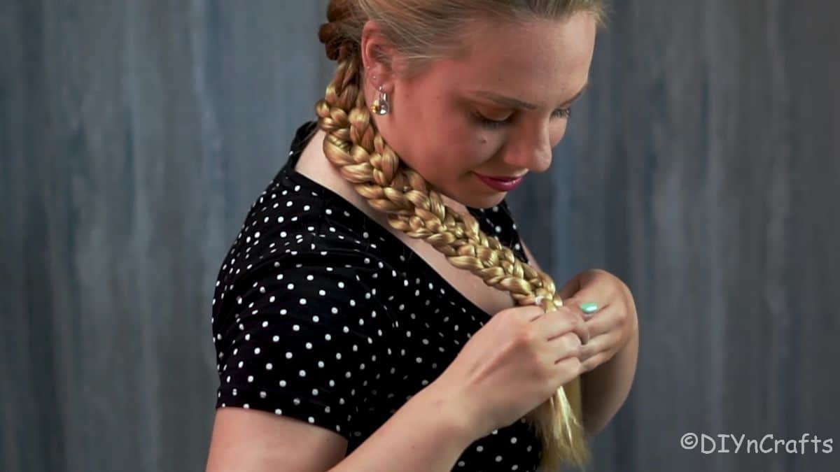 blonde woman tying the end of her braid