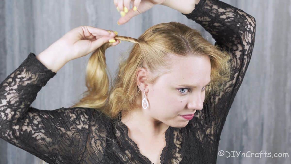 blonde woman twisting hair behind head
