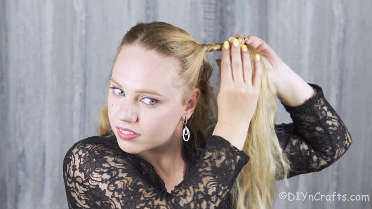 blonde woman twisting side of her hair