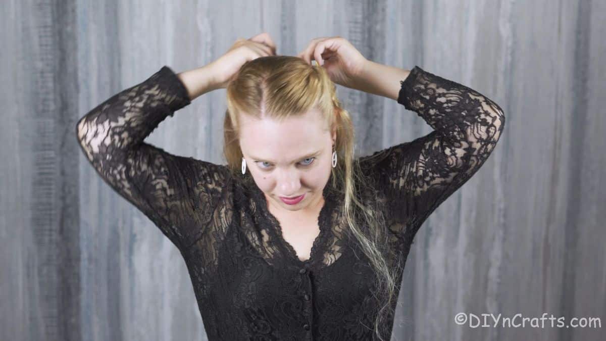 blonde woman pulling twisted hair sides back