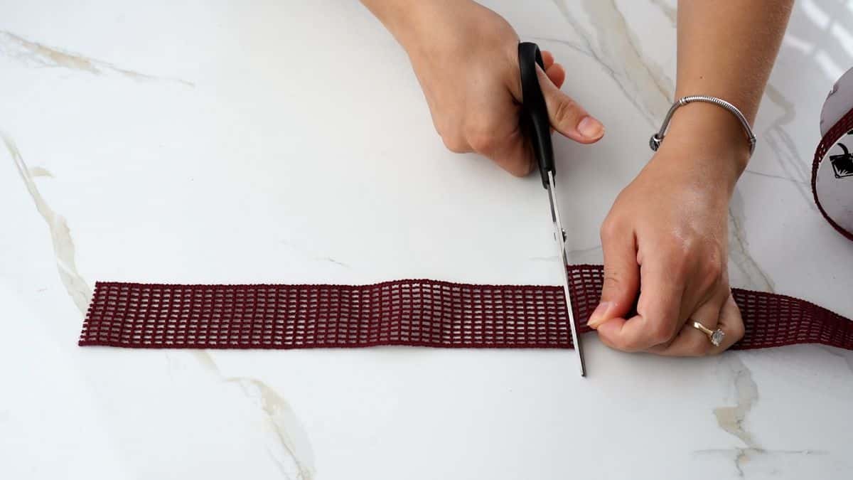 scissors cutting maroon ribbon