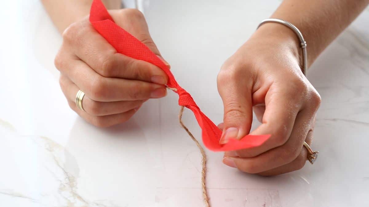 red ribbon being tied on twine