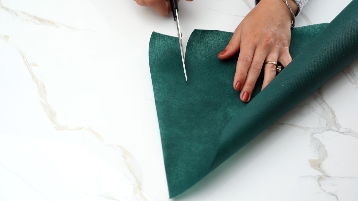 scissors slicing through green fabric