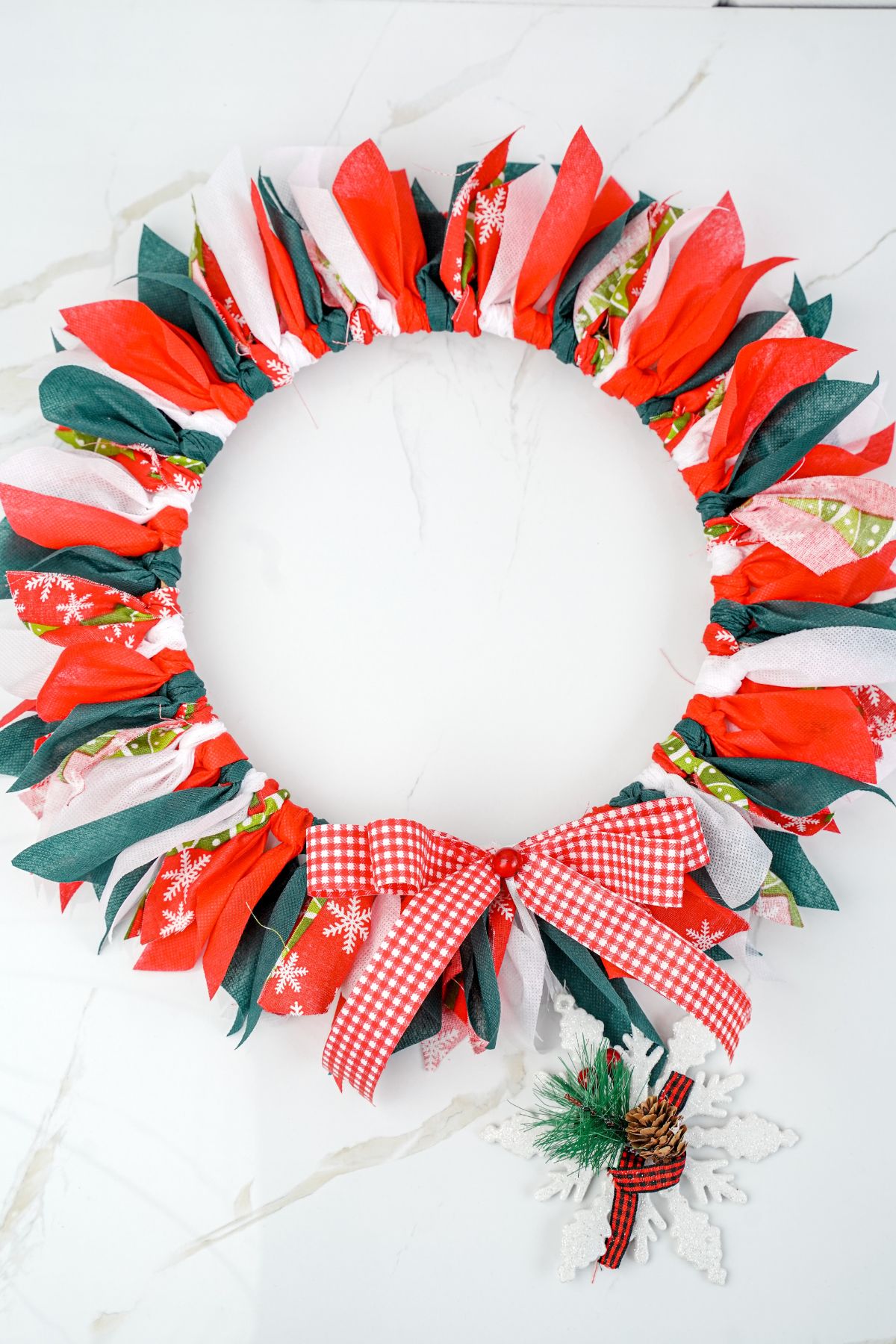 Christmas rag wreath laying on a marble table