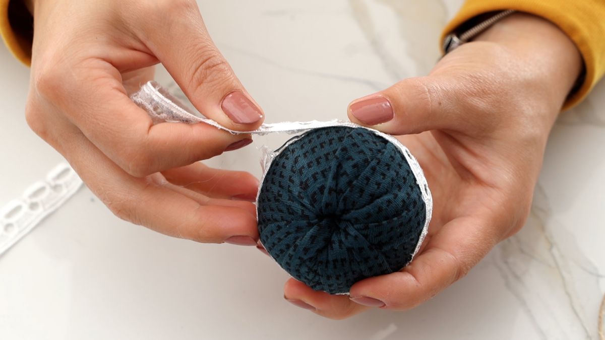 gluing lace around middle of fabric ball ornament