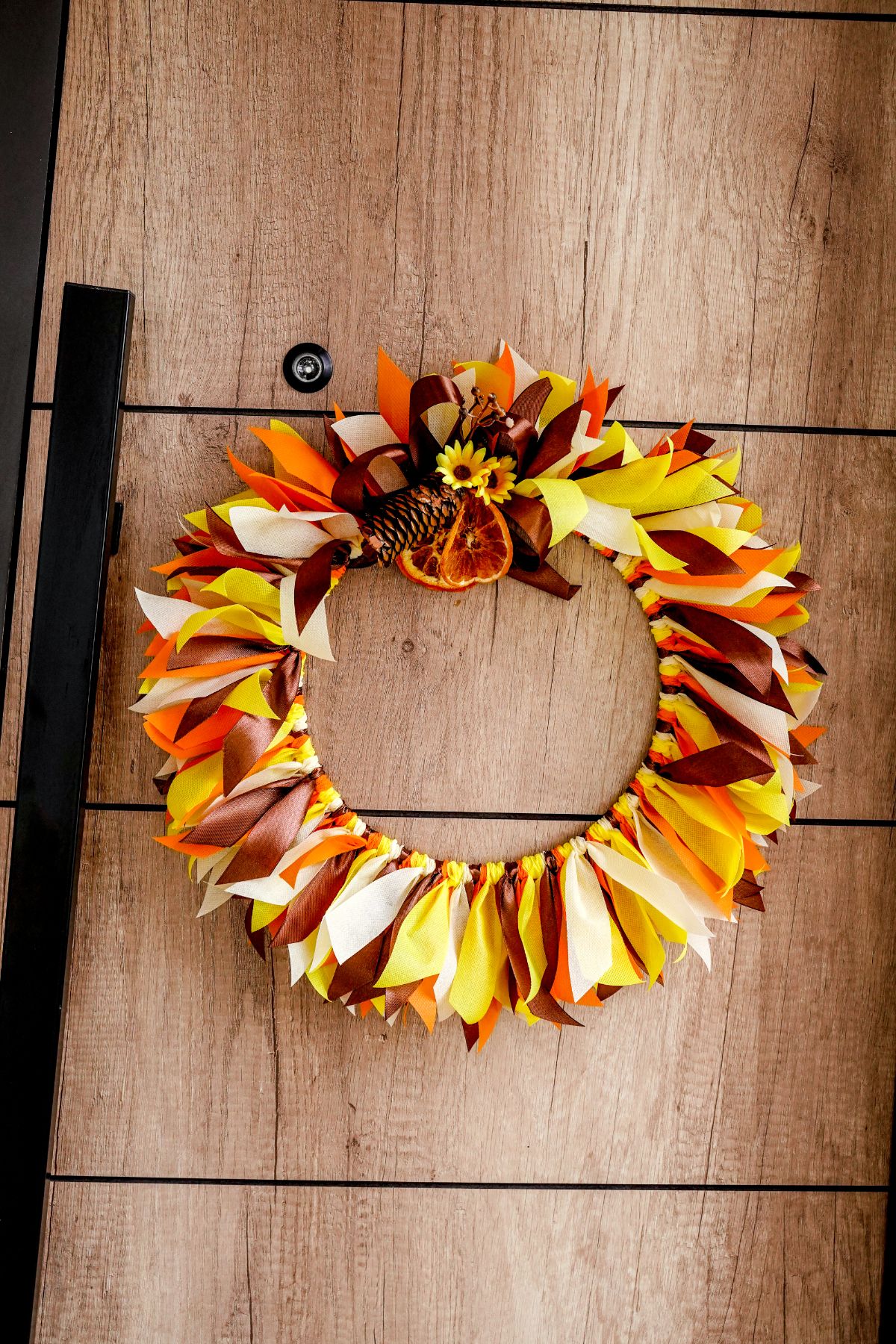 fall wreath against wood paneling