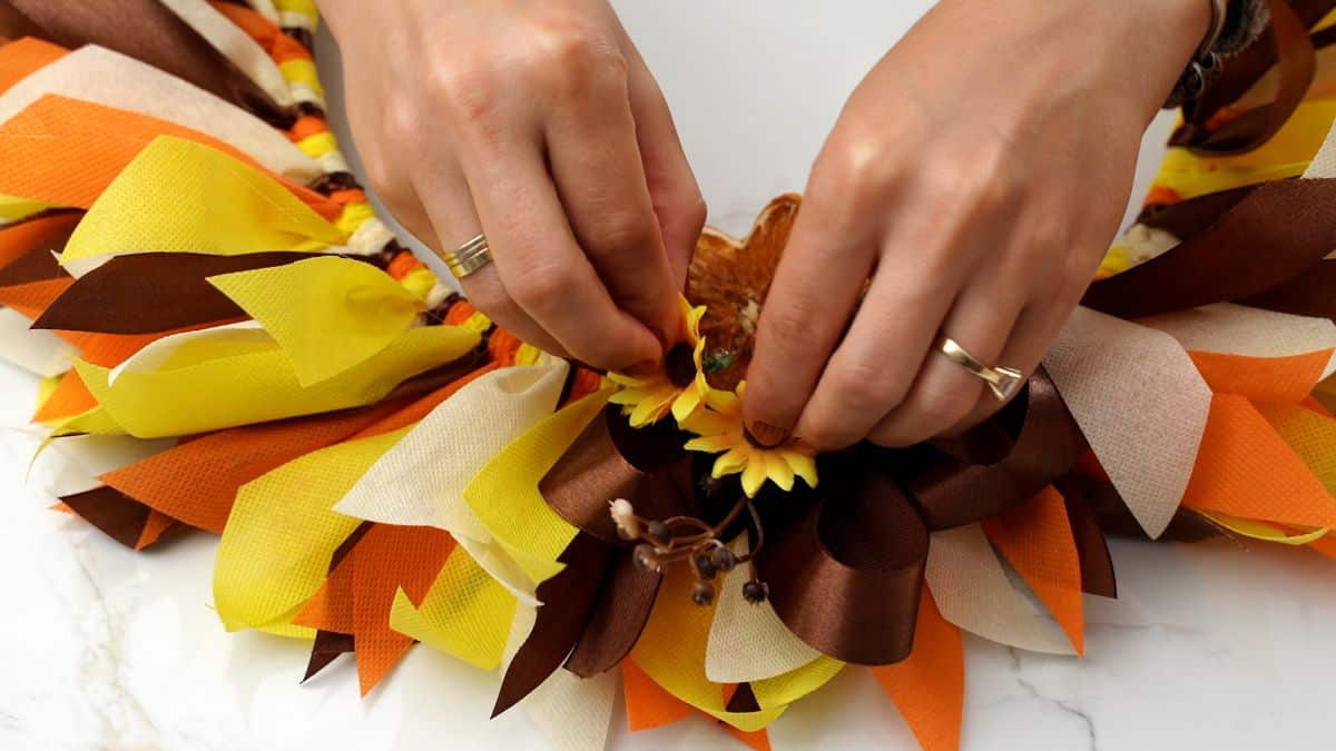flowers being glued onto fall rag wreath
