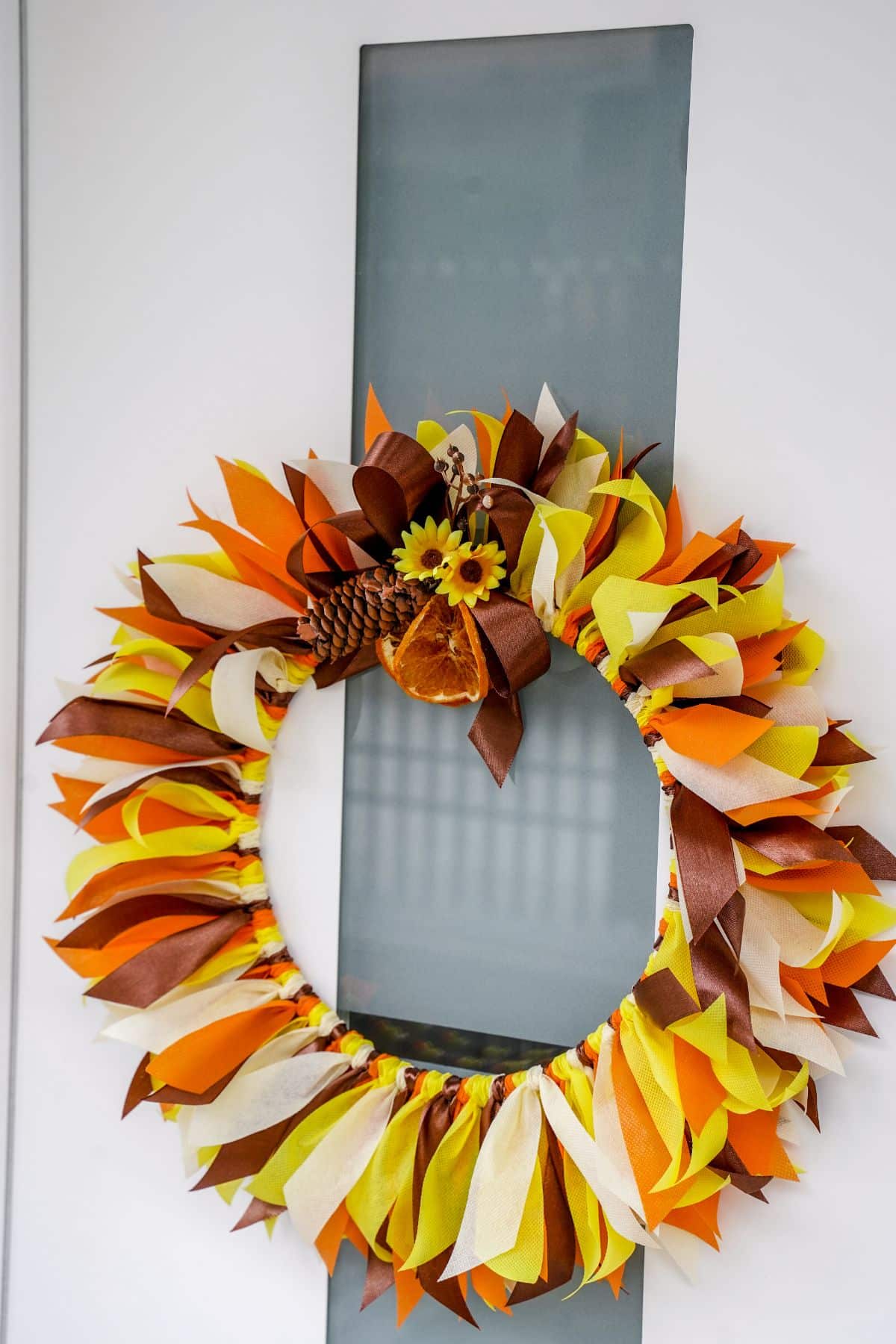 white and glass door with fall rag wreath on center
