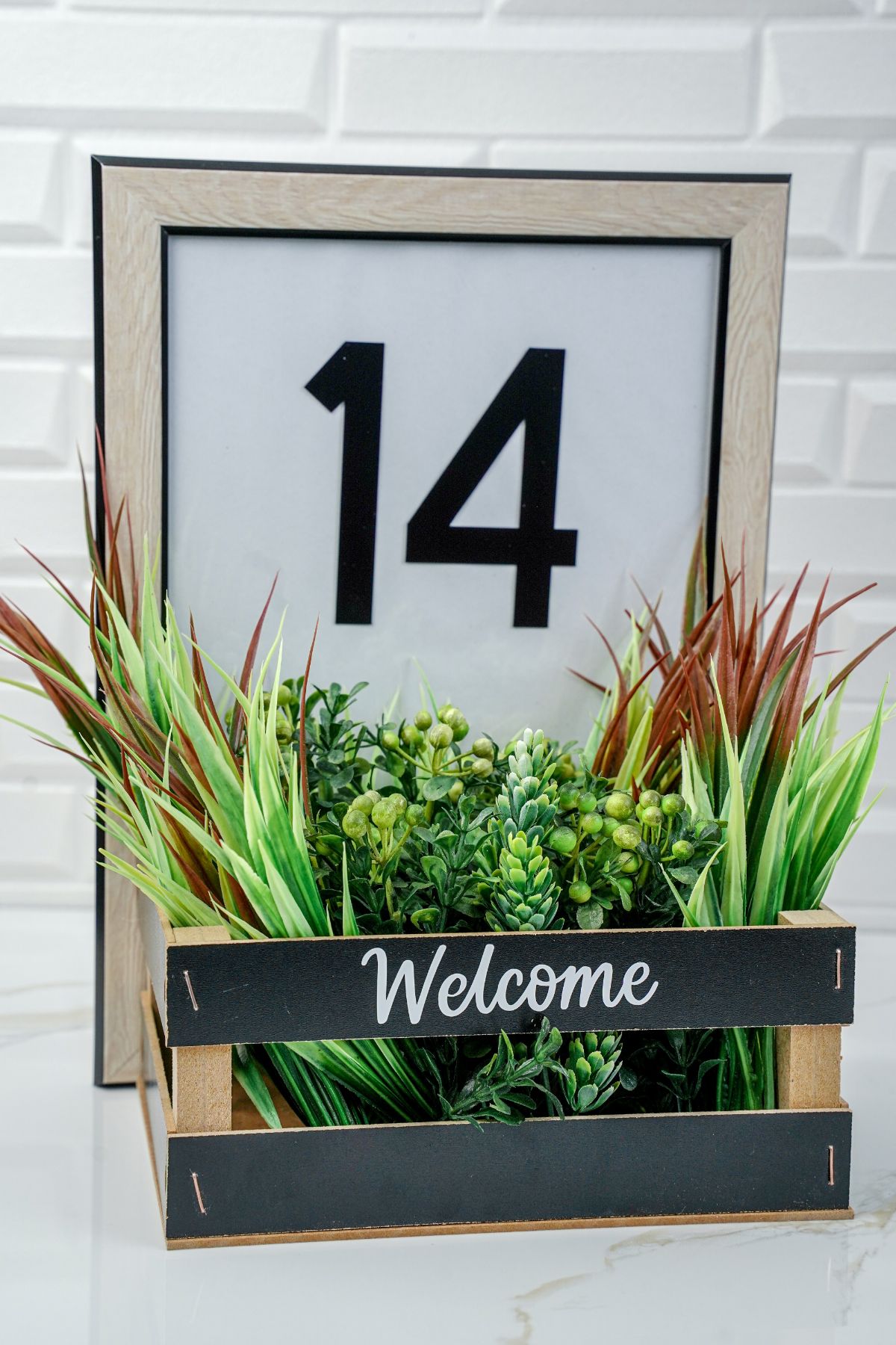 black basket with white welcome message on front of framed house number sign