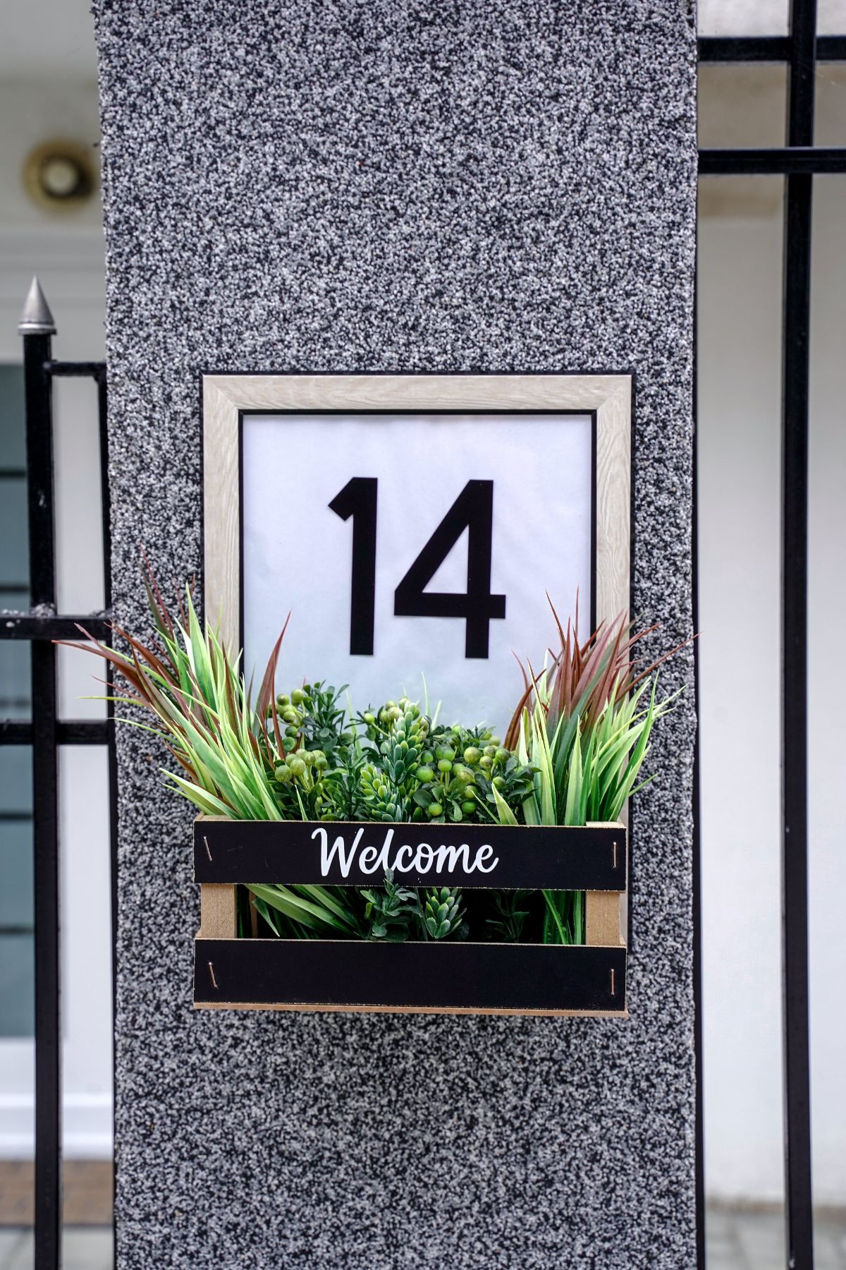 house number sign with basket against grey column