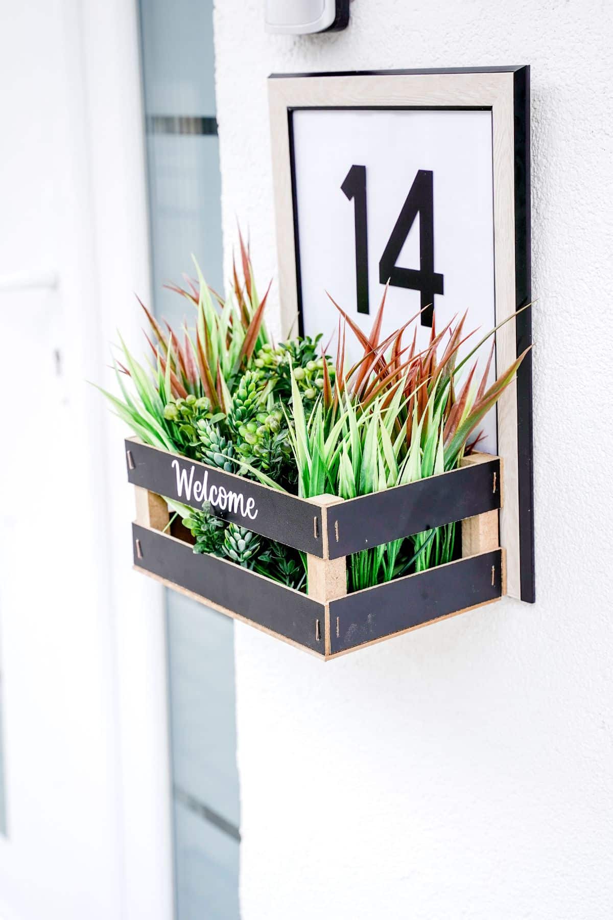 side of house number sign against white stucco wall