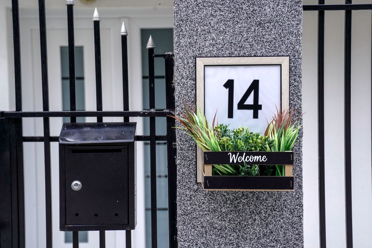 welcome across basket on house number sign