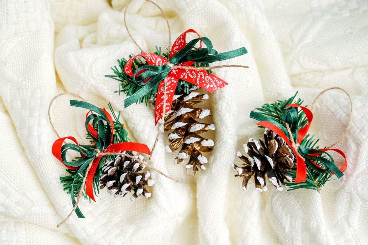 three pinecone ornaments on white blanket
