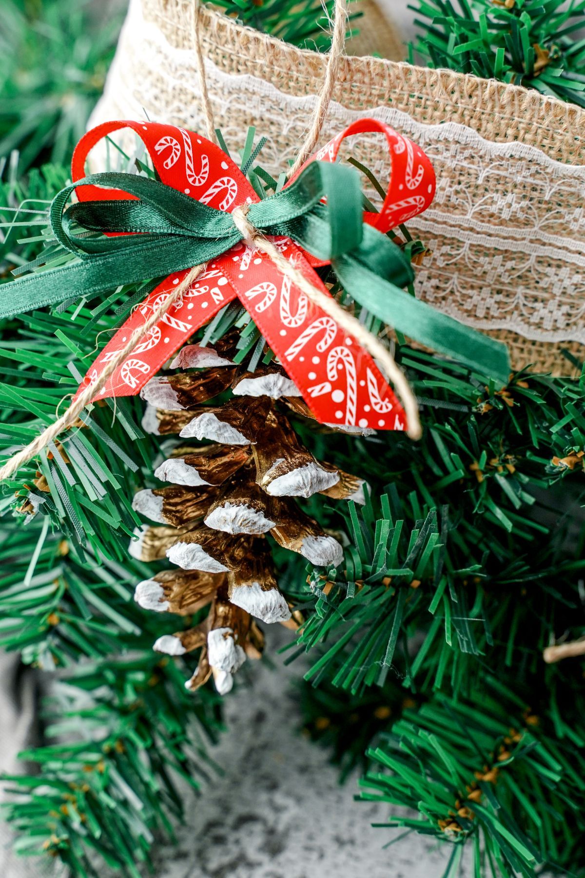 Burlap lace on fake tree with pinecone ornament hanging