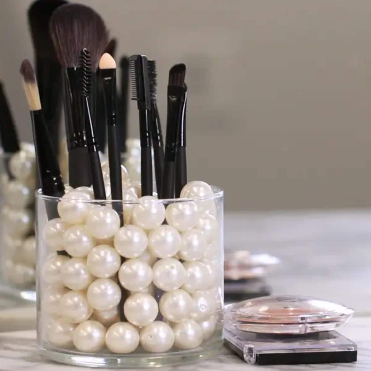 A repurposed candle jar as a make-up organizer.