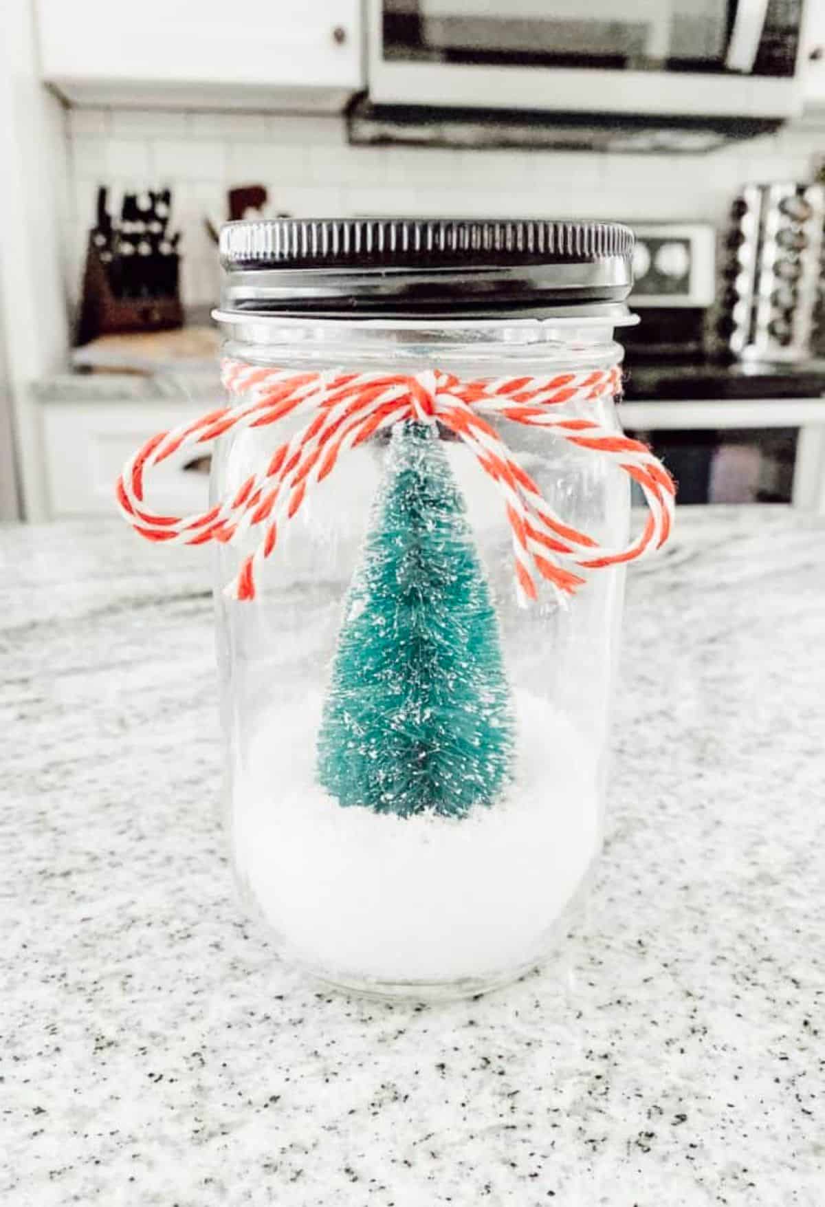 A candle jar repurposed as a snow globe.