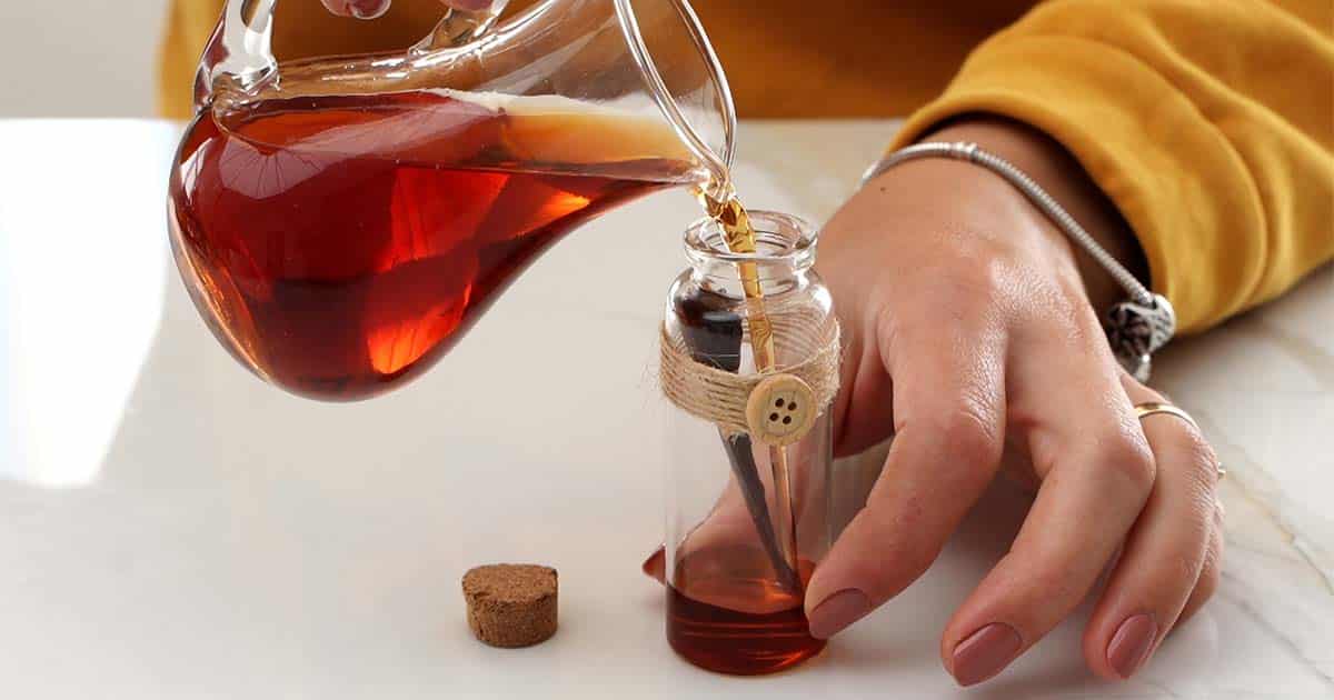 pouring diy cinnamon extract into a bottle for a gift
