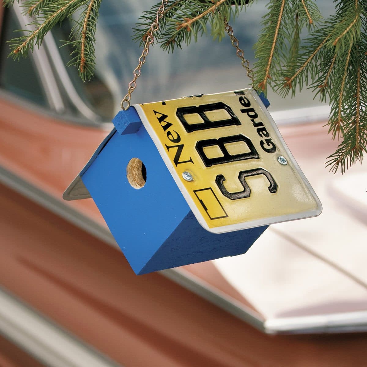 license plate birdhouse hanging on tree branch