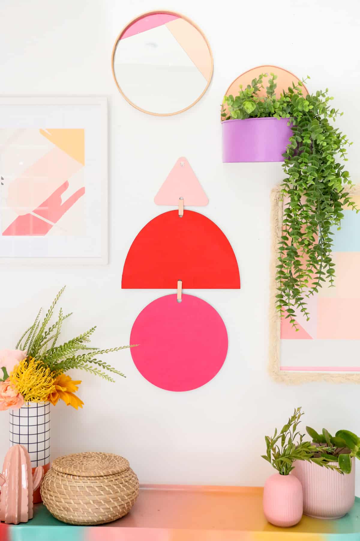 geometric wall hanging and surrounding flower pots