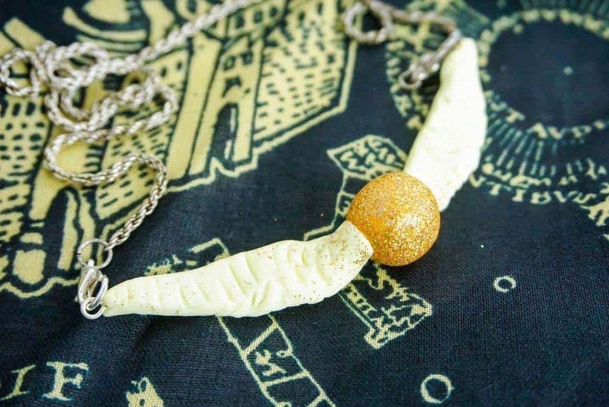 golden snitch necklace on towel