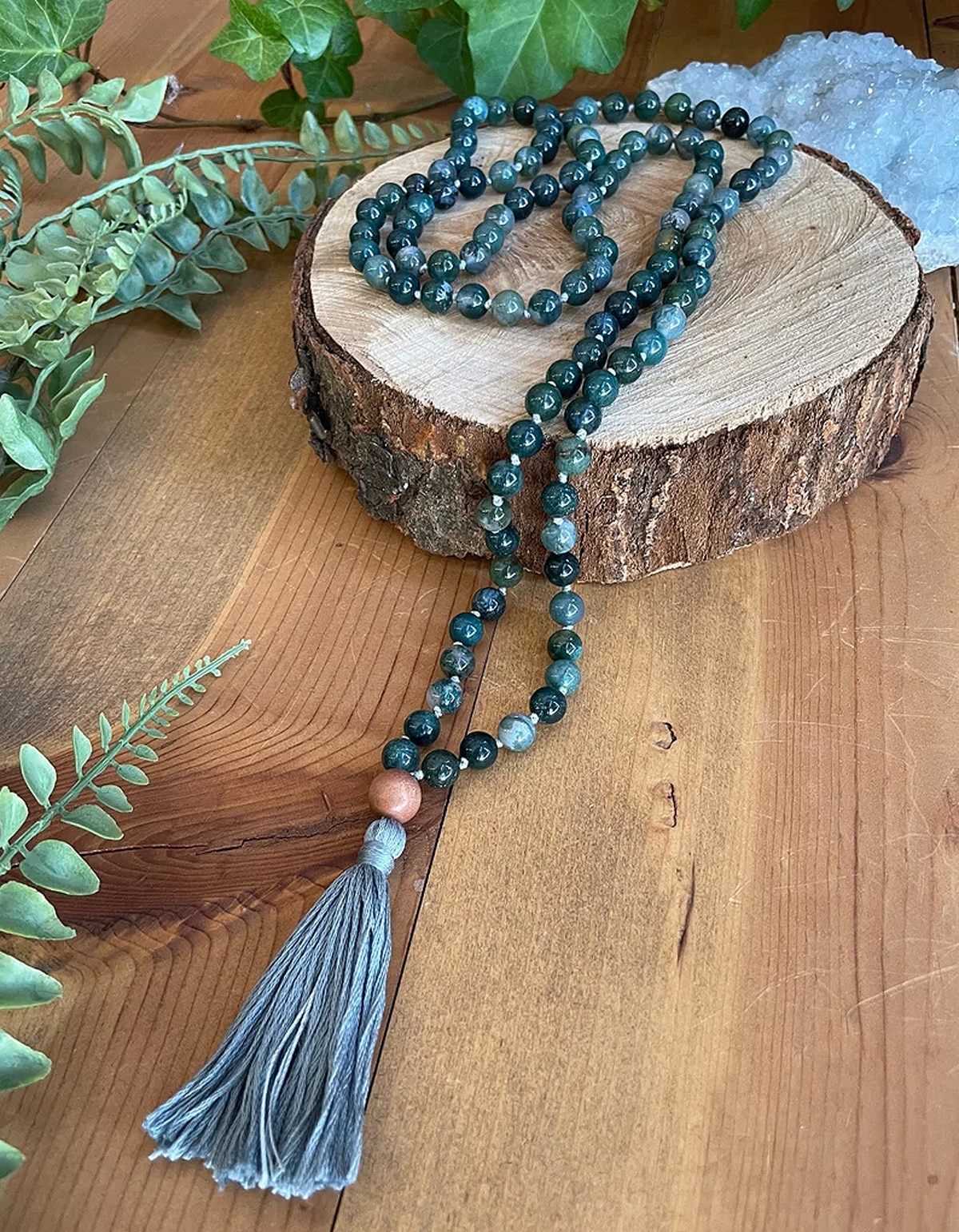 mala necklace kit on piece of wood placed on table