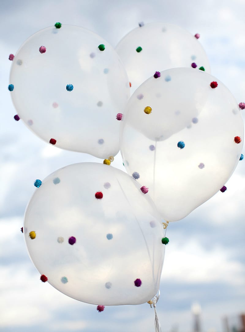 balloons into festive displays with small pom poms